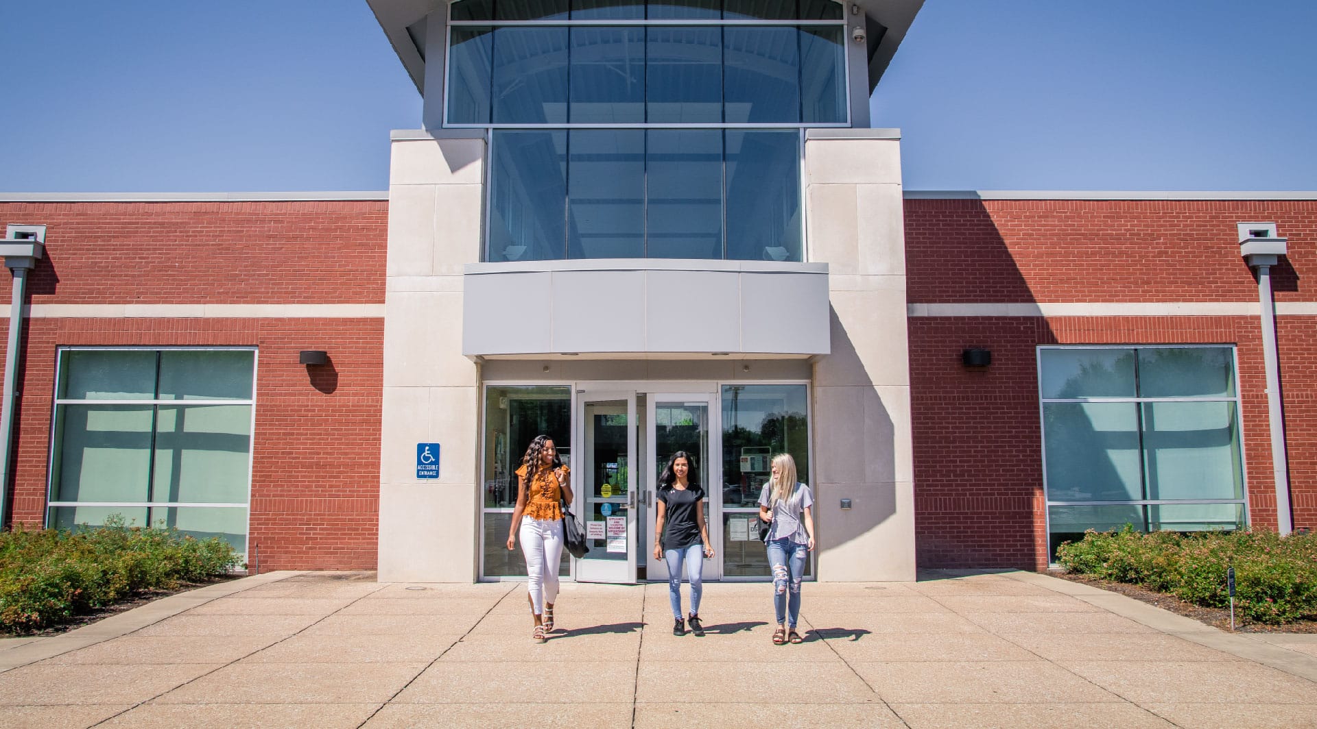 Three students walking in front of a building