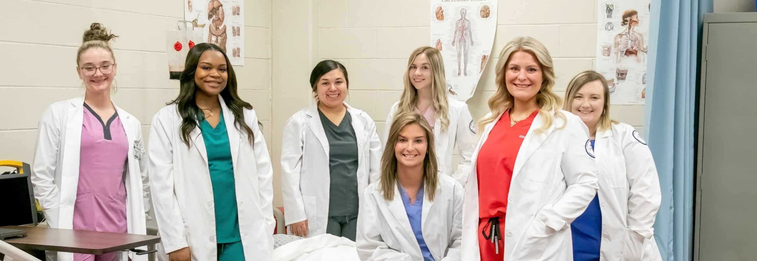Nursing students standing around patient.