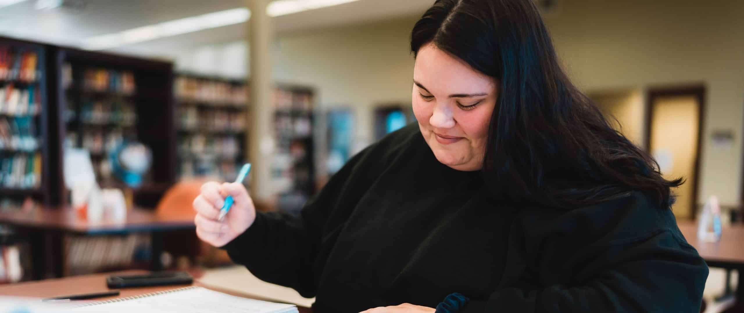 Student writing in a notebook.